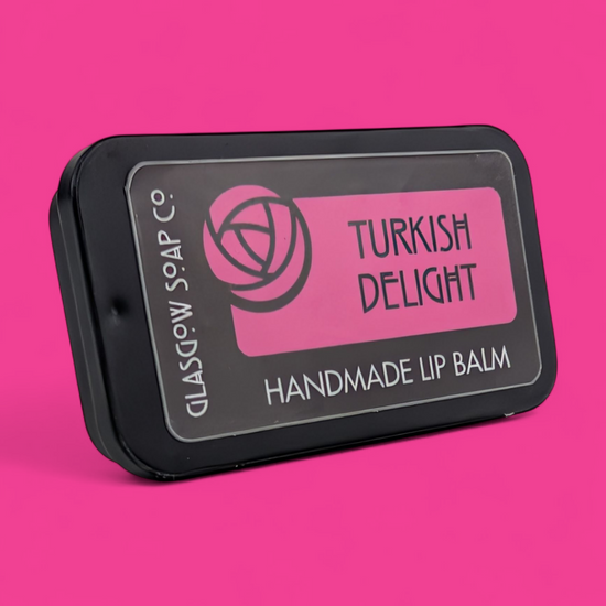 Handmade lip balm packaging with 'Turkish Delight' flavor on a pink background