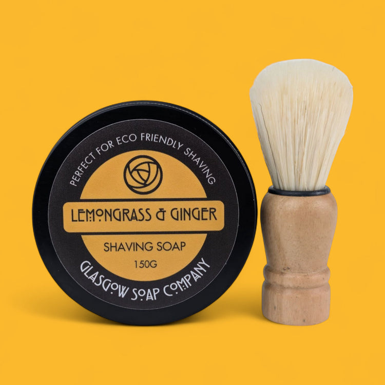 Shaving soap container and brush with 'Lemongrass & Ginger' label on a yellow background