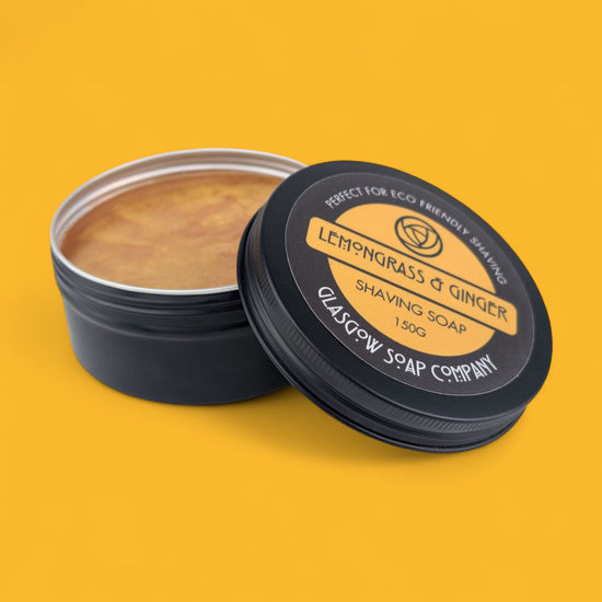 Shaving soap in a black container with 'Lemongrass & Ginger' label on a yellow background