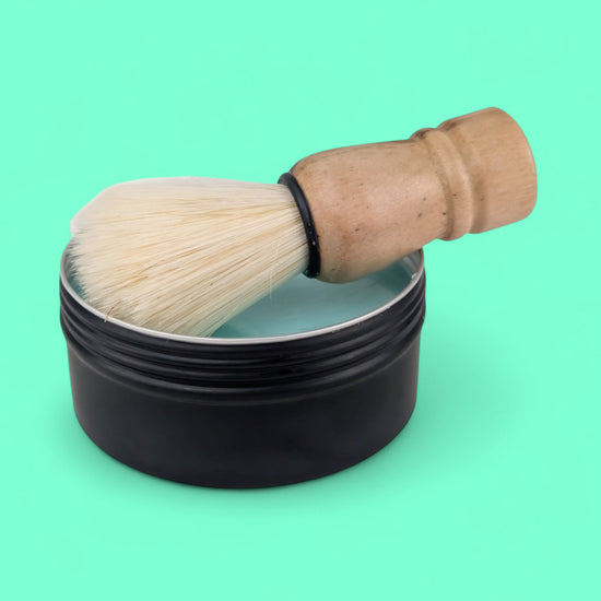 Shaving brush and black container on a green background