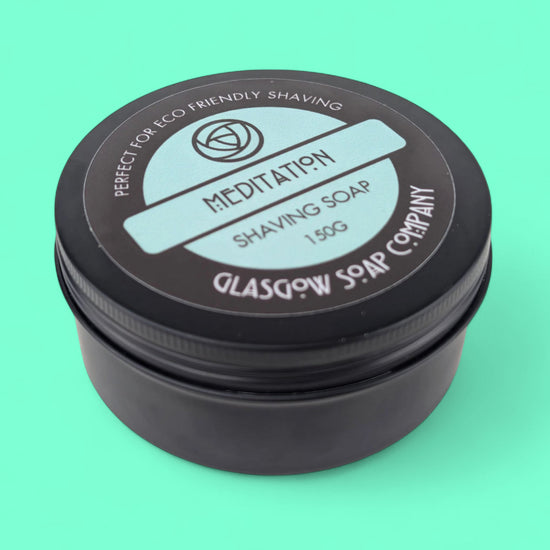 Shaving soap container with 'Meditation' and 'Glasgow Soap Company' branding on a teal background