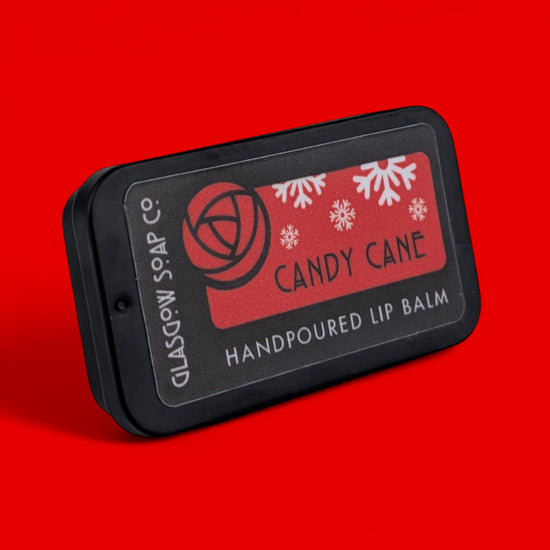 Handpoured lip balm packaging with 'Candy Cane' label on a red background