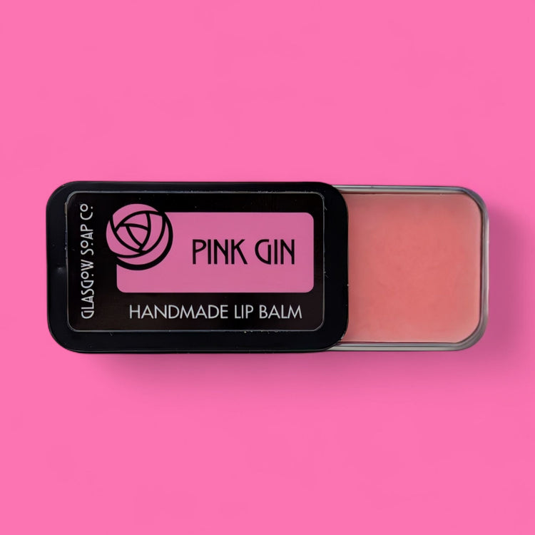 Handmade lip balm in a black container with 'Pink Gin' branding on a pink background