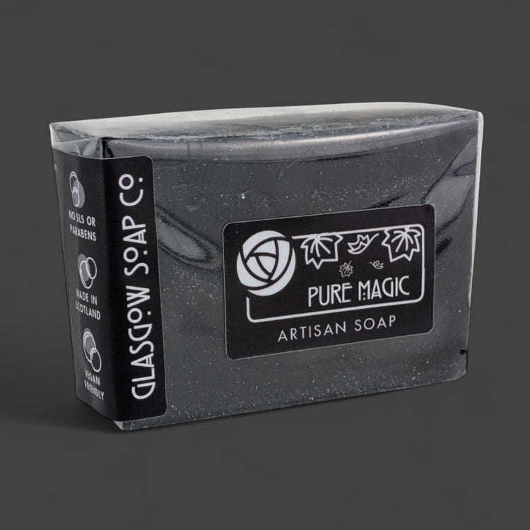 Black artisan soap bar with 'Pure Magic' label on a dark background