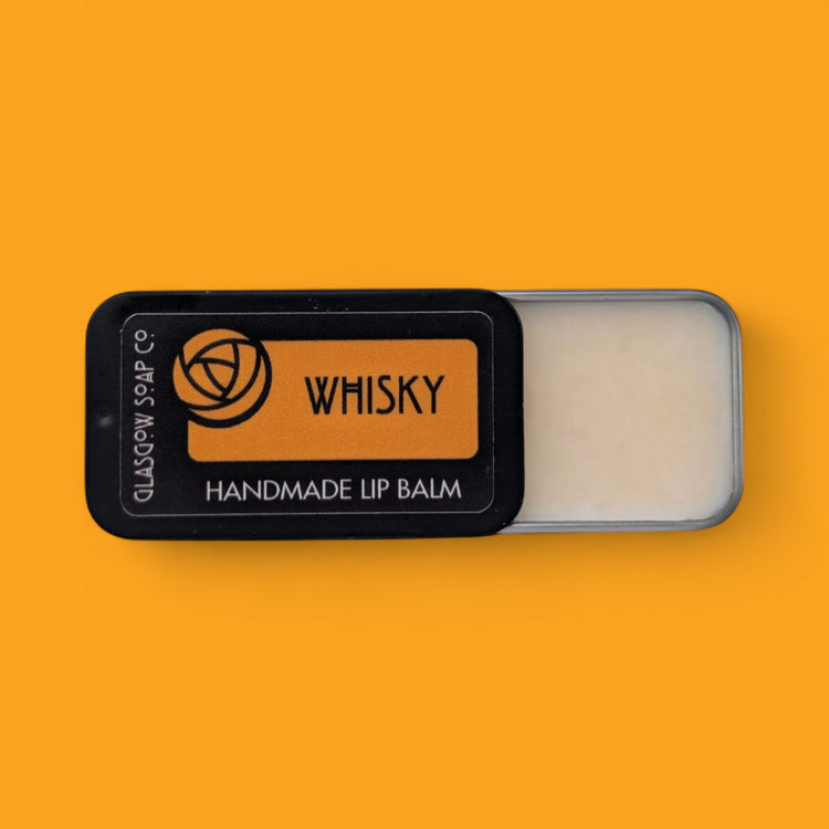 Handmade lip balm labeled 'Whisky' on an orange background