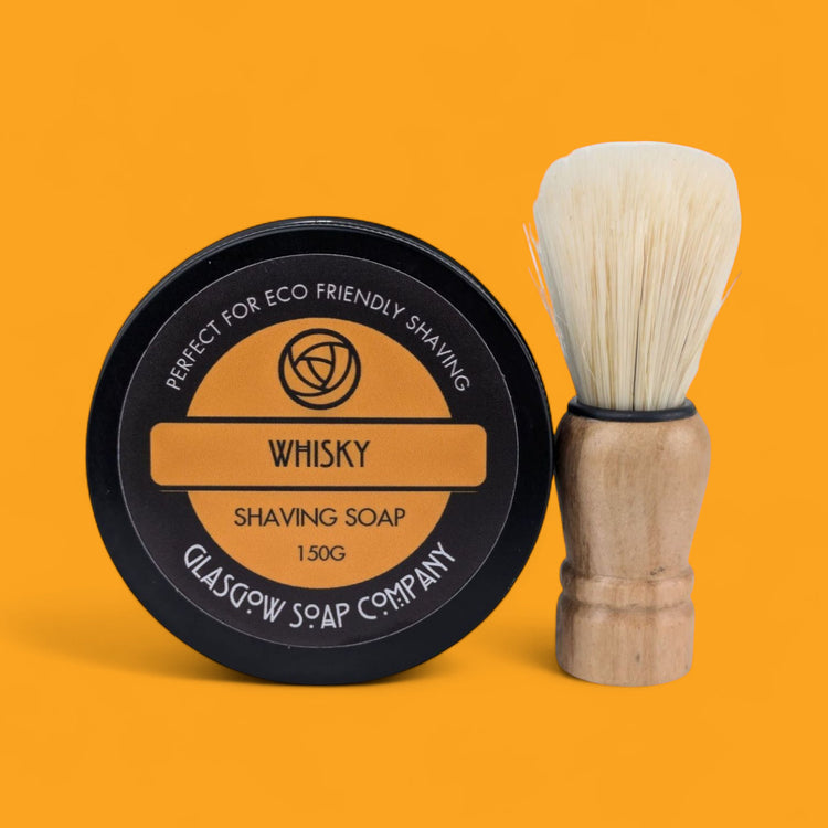 Shaving soap container and brush on an orange background