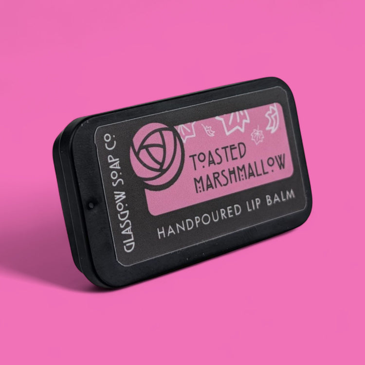 Handpoured lip balm packaging with 'Toasted Marshmallow' flavor on a pink background