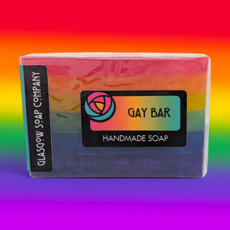 Handmade soap bar with 'Gay Bar' label on a rainbow gradient background