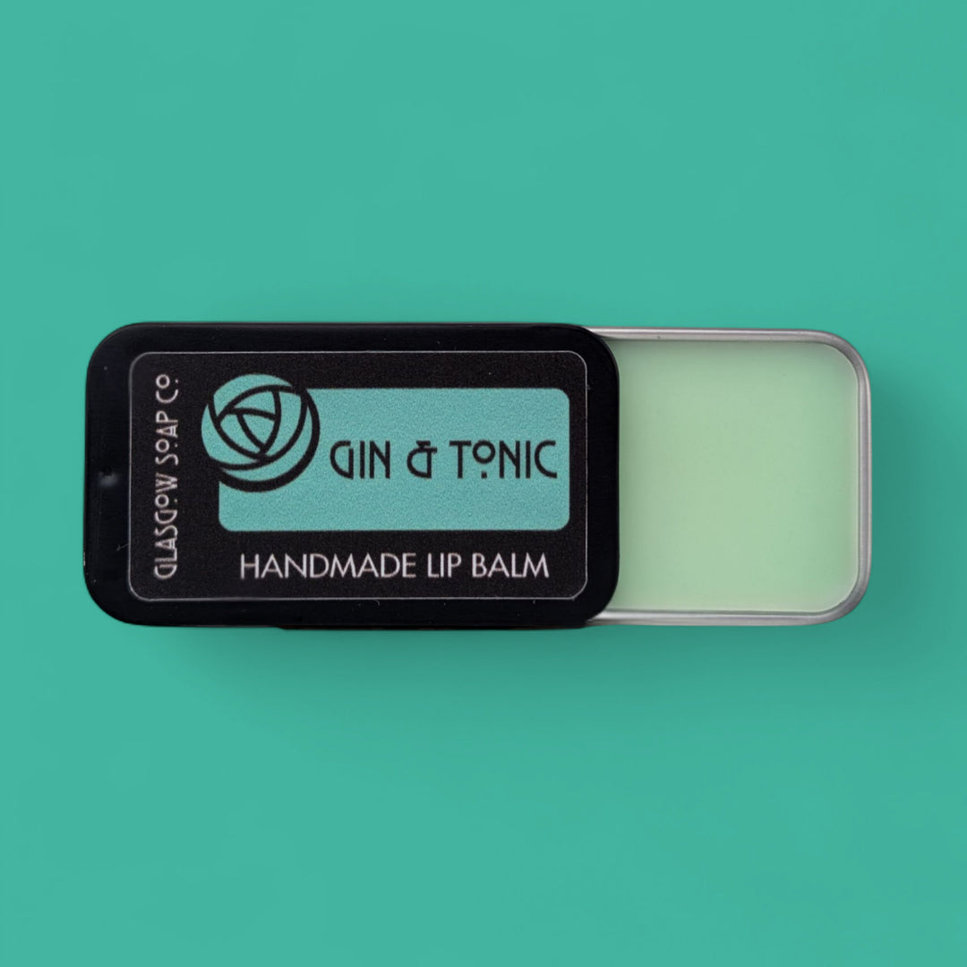 Handmade lip balm with 'Gin & Tonic' flavor on a teal background