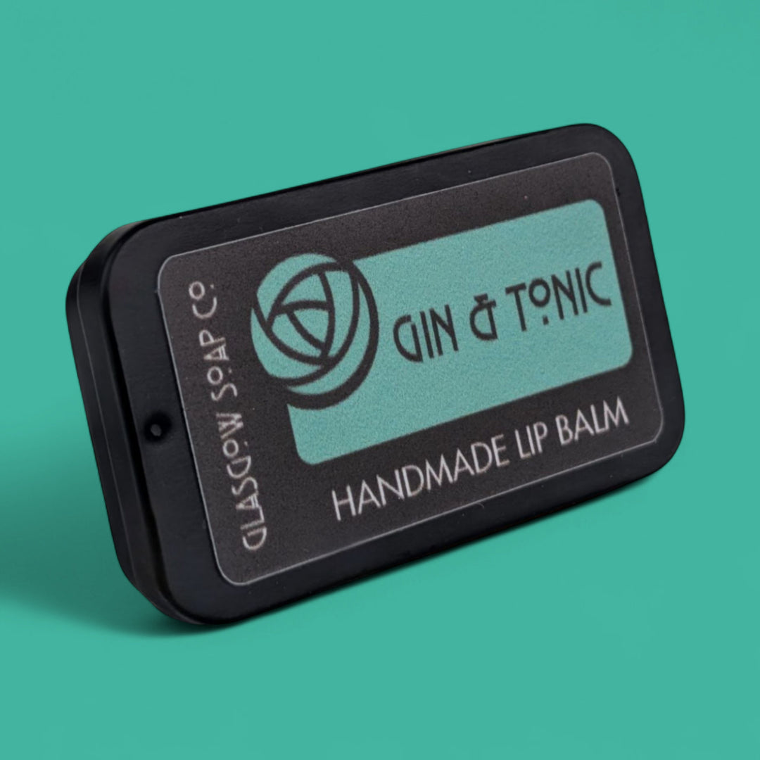 Handmade lip balm packaging with 'Gin & Tonic' branding on a teal background