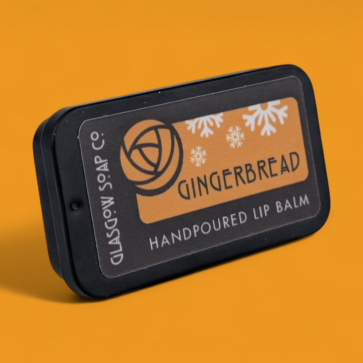 Gingerbread christmas lip balm packaging with 'Glasgow Soap Co.' branding on an orange background
