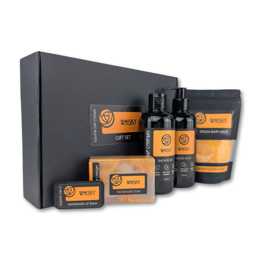 Whisky-themed gift set with various products including soap, lip balm, and bath salts on a white background.