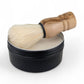 Shaving brush with wooden handle and black container on a white background