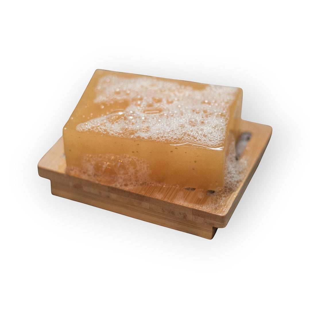 Glasgow Soap Company Ltd Lemongrass &amp; Ginger artisanal soap bar with lather on a bamboo soap dish.