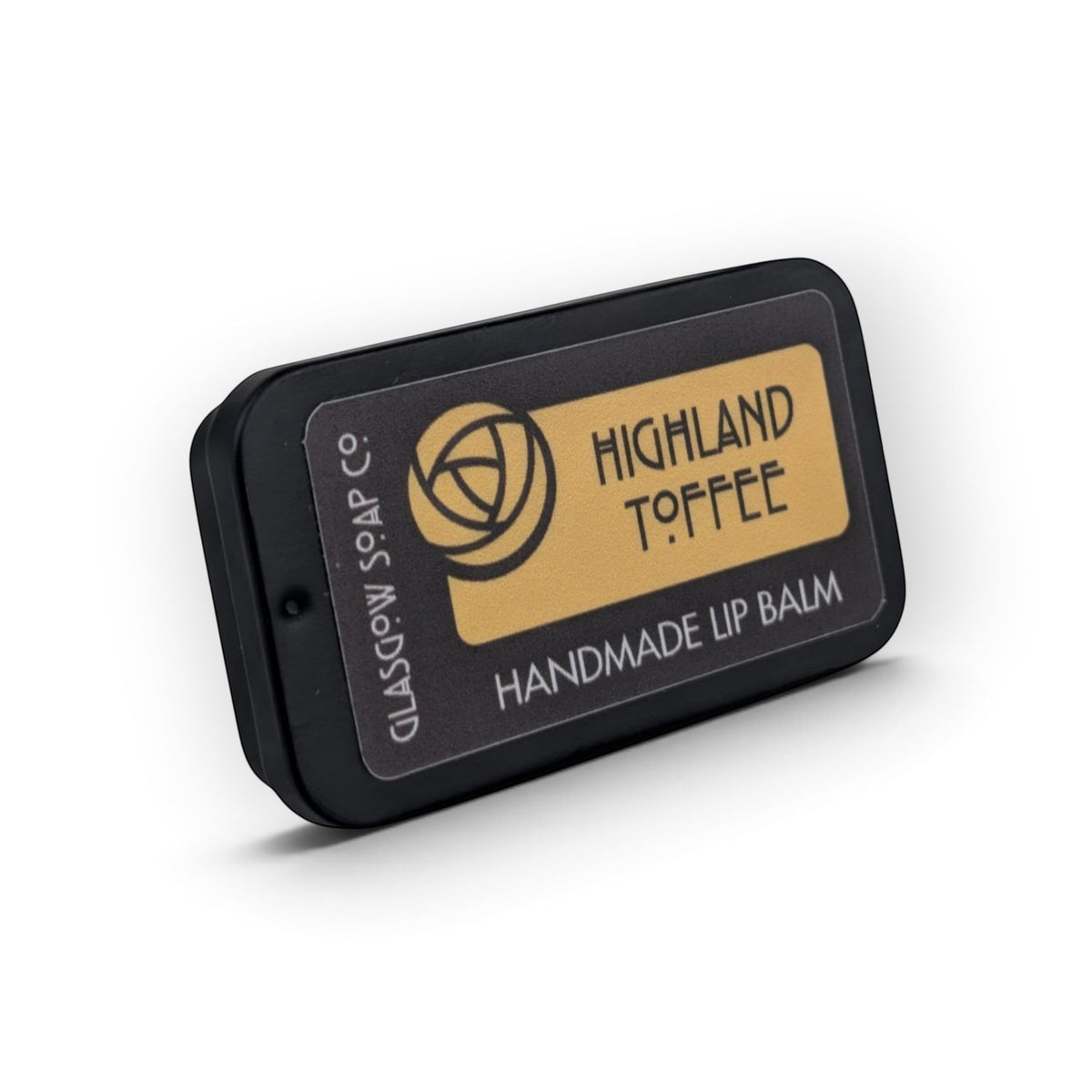 Glasgow Soap Company Ltd Highland Toffee lip balm in a small black sliding tin with gold label branding.
