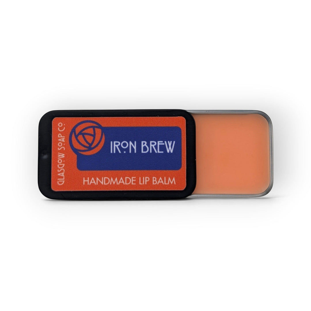 Glasgow Soap Company Ltd Iron Brew lip balm in a sliding metal tin with orange balm and Scottish-inspired branding.
