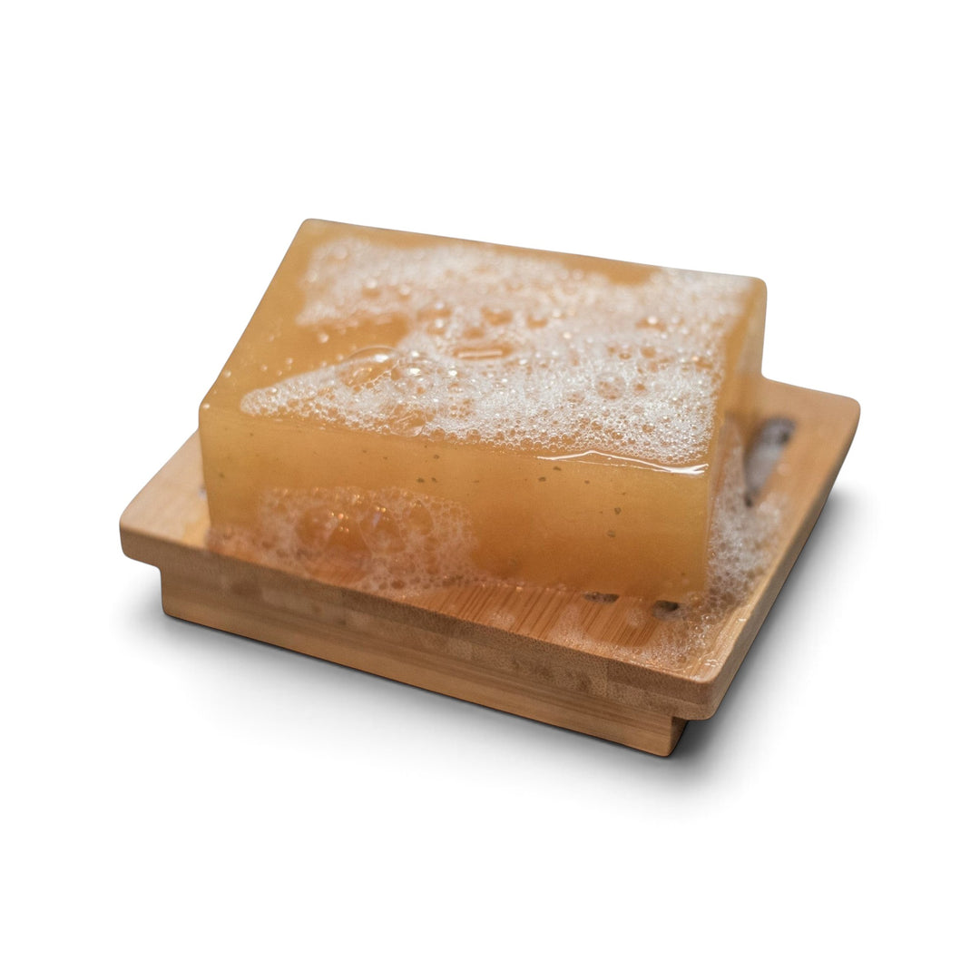 Glasgow Soap Company Ltd lemongrass and ginger vegetable glycerine soap bar with lather on a wooden soap dish