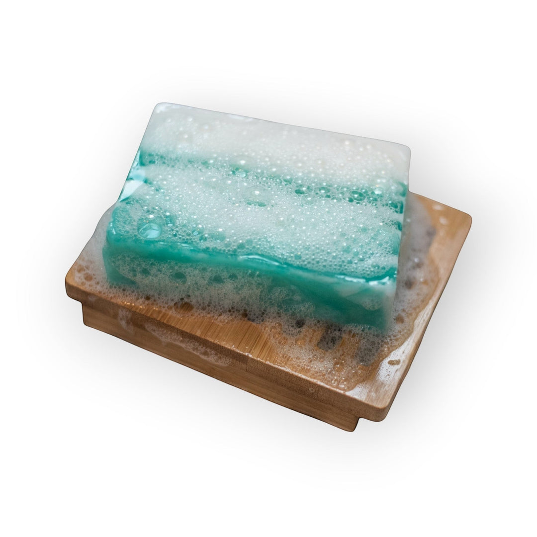 Glasgow Soap Company Ltd Meditation Soap, a marbled teal and white bar with white foam on a bamboo soap dish.