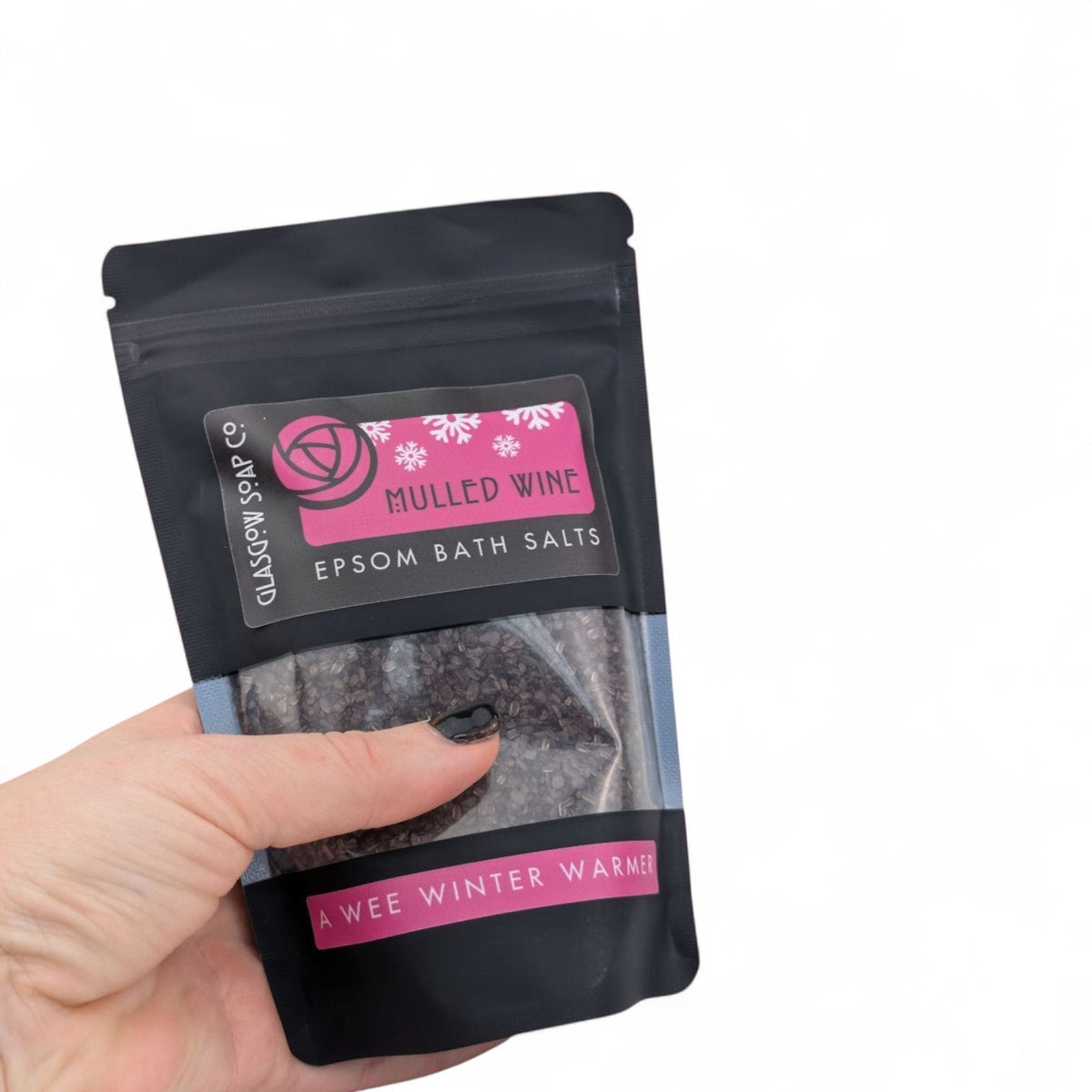 Glasgow Soap Company Ltd Mulled Wine Epsom bath salts in a black recyclable sachet held in a hand.
