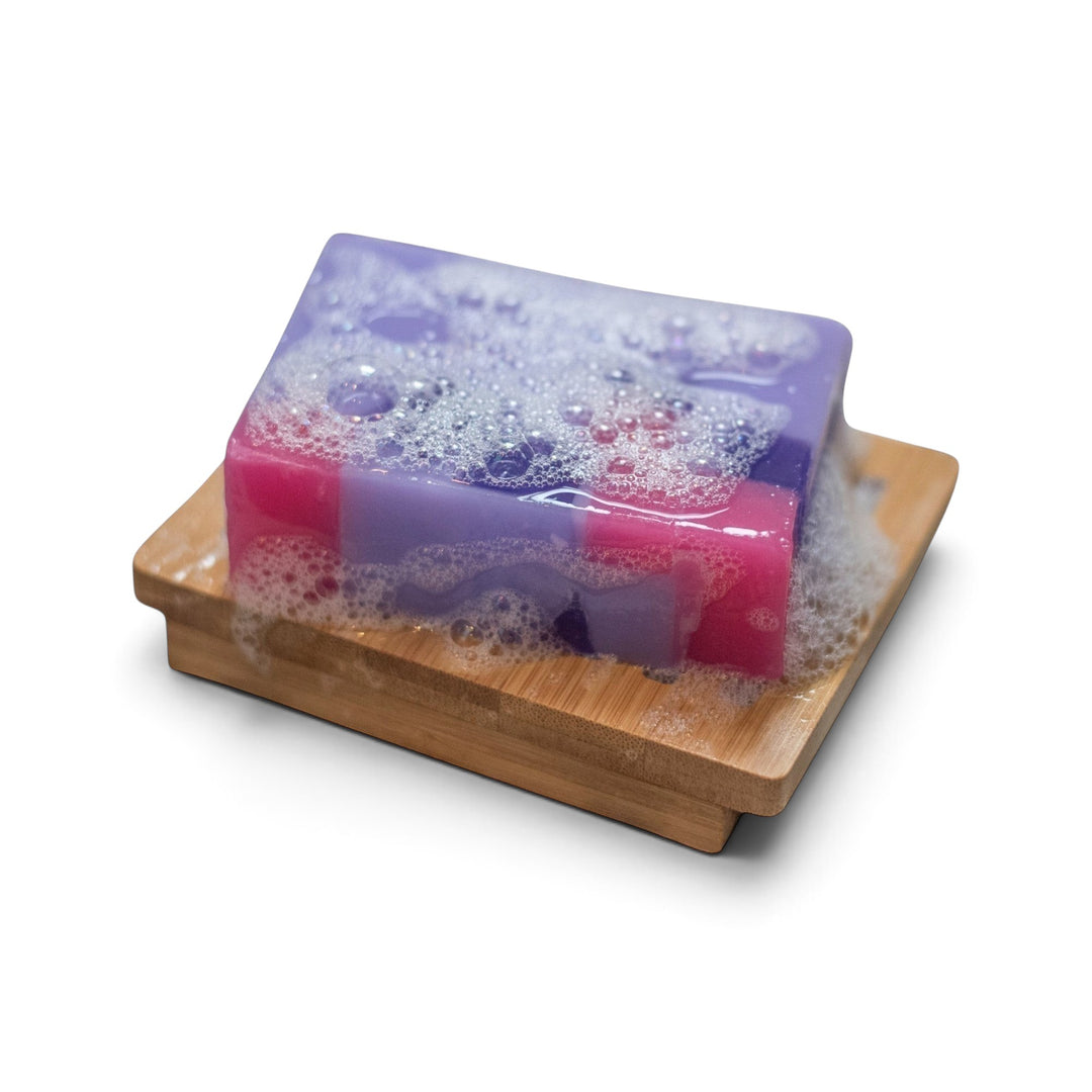 Glasgow Soap Company Ltd Parma Violet soap bar with purple and pink layers, lathering on a wooden soap dish.