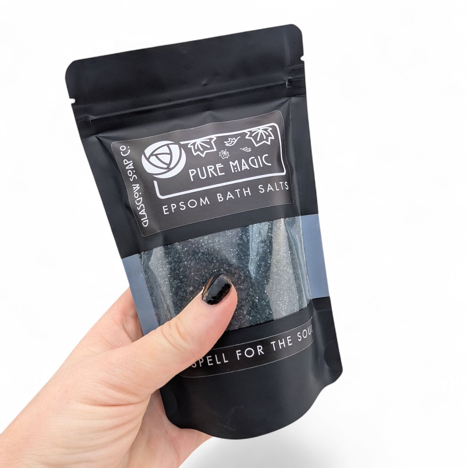 Glasgow Soap Company Ltd Pure Magic dark Epsom bath salts in a black recyclable sachet held in a hand