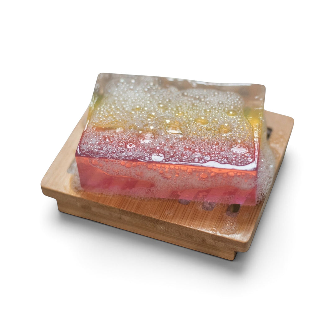 Glasgow Soap Company Ltd rhubarb and ginger soap bar with bubbly lather on a wooden soap dish