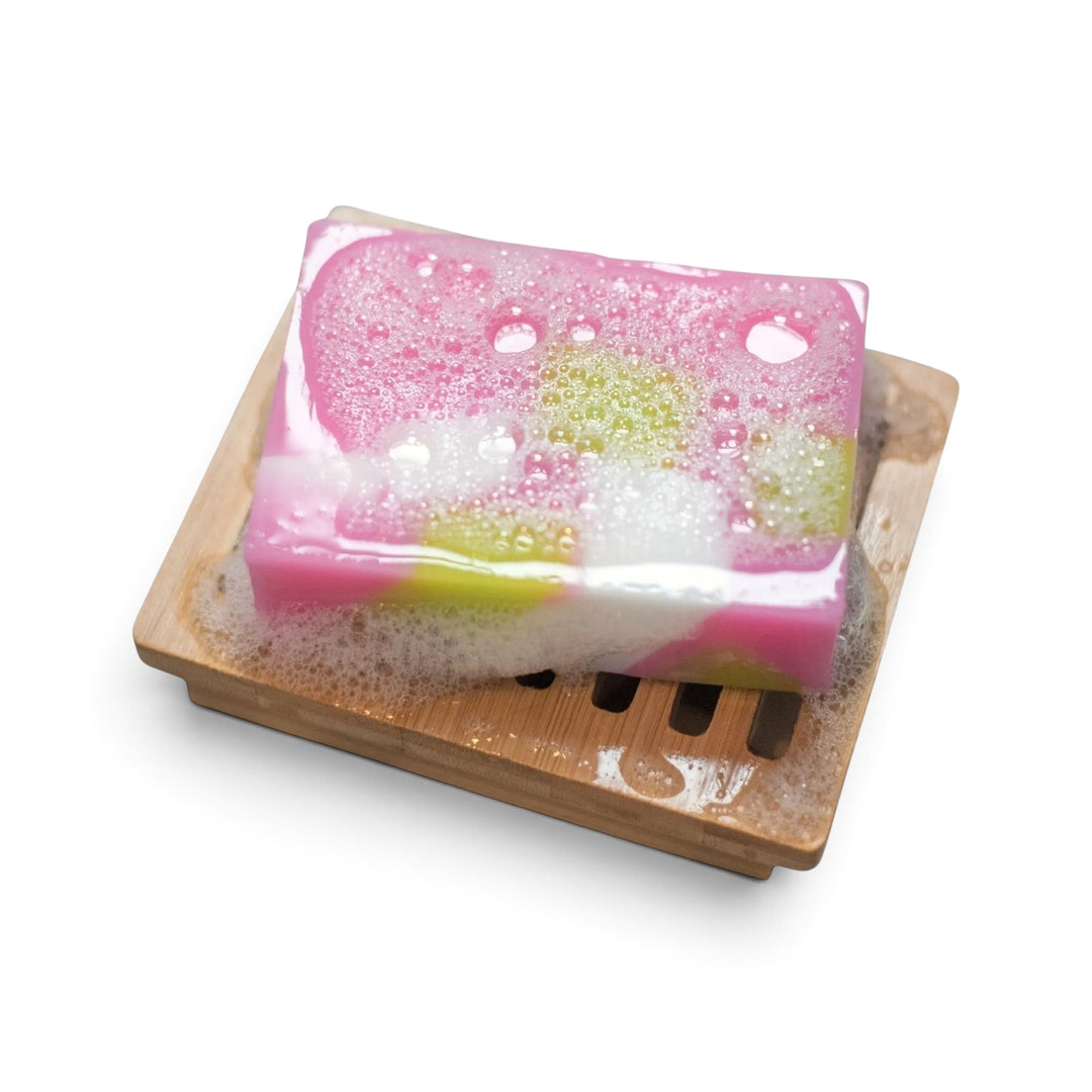 Glasgow Soap Company Ltd Scottish Rose soap bar with pink and green swirls in a lather on a wooden soap dish