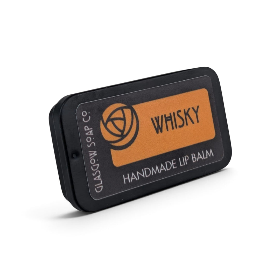 Glasgow Soap Company Ltd Whisky lip balm in a small black sliding tin with orange label, hand-poured in Scotland.