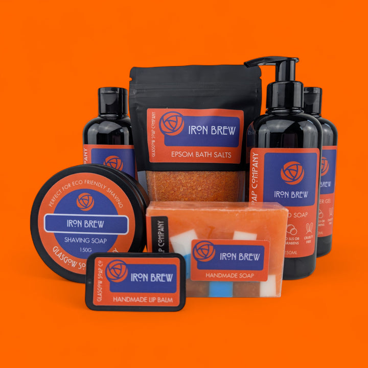 Collection of Irn bru products including soap, shampoo, and bath salts on an orange background