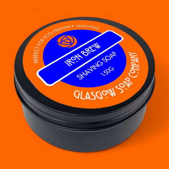 Shaving soap container with 'Iron Brew' branding on an orange background