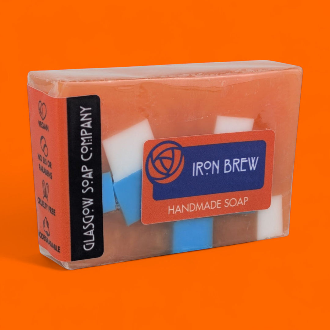 Handmade soap bar with 'Iron Brew' branding on an orange background