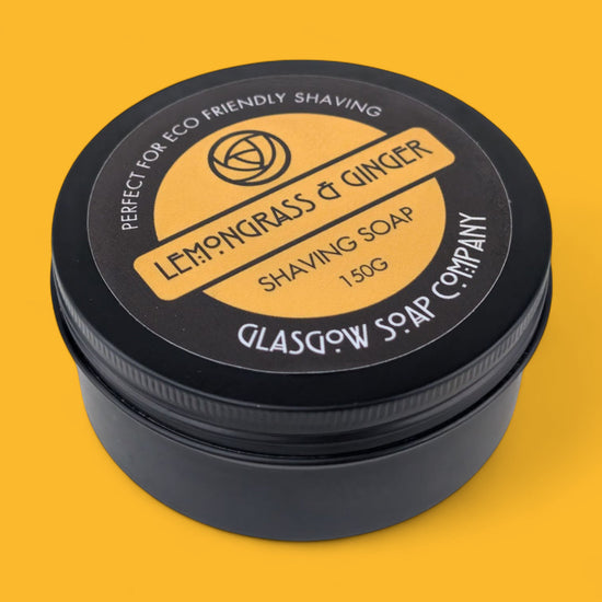 Shaving soap container with 'Lemongrass & Ginger' label on a yellow background