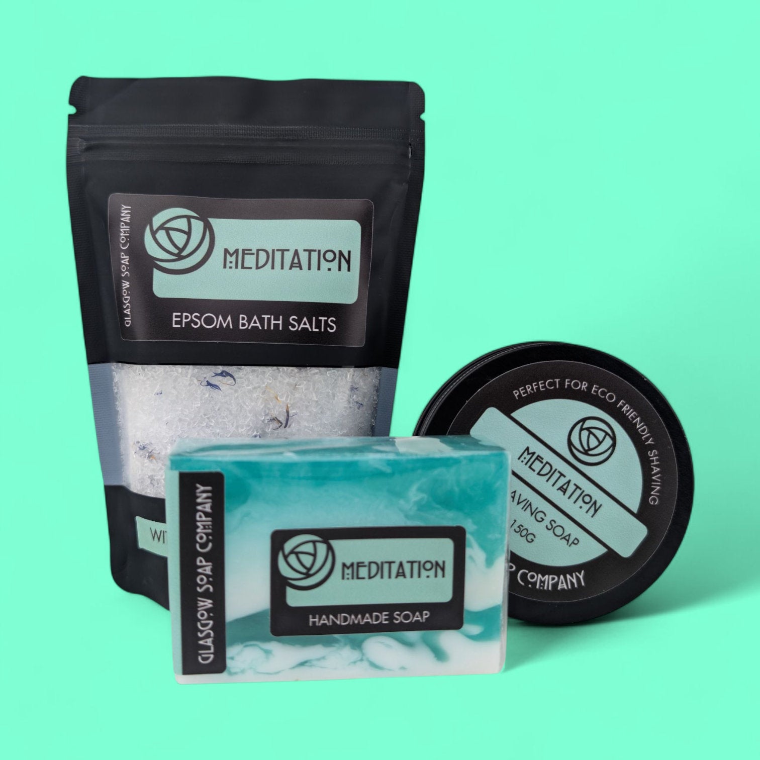 Meditation bath and body products including bath salts, soap, and shaving soap on a teal background
