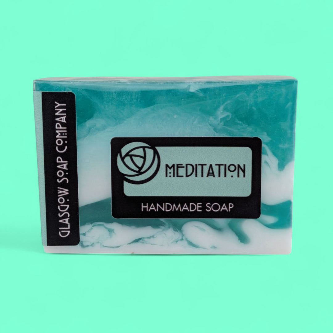 Handmade soap bar with 'Meditation' label on a teal background