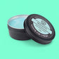 Black tin of shaving soap with 'Meditation' label on a teal background