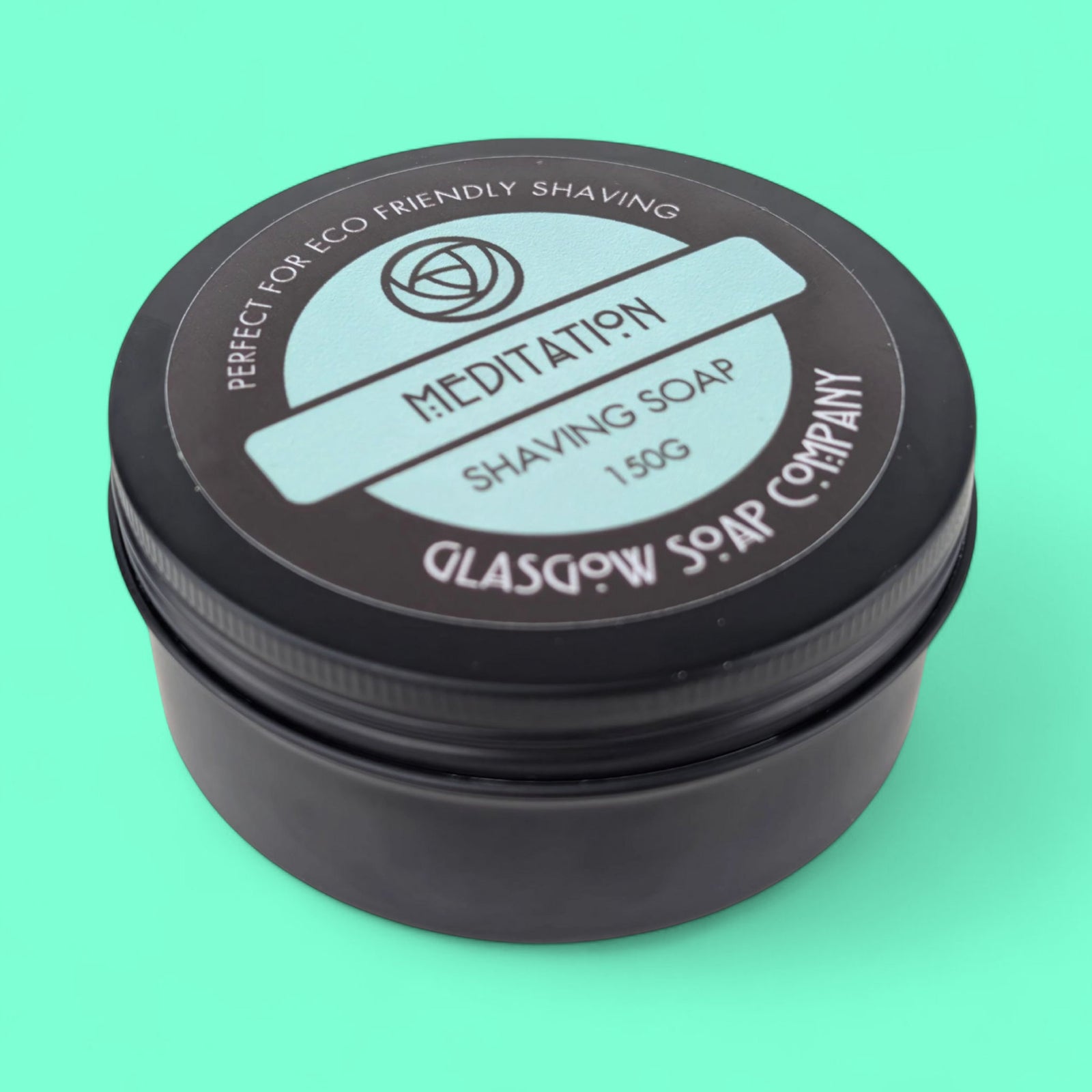 Shaving soap container with 'Meditation' and 'Glasgow Soap Company' branding on a teal background
