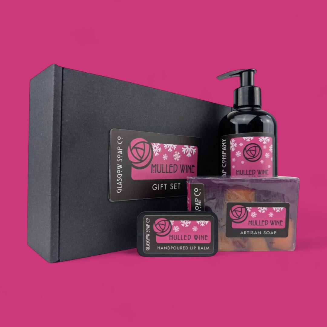 Glasgow Soap Co. mulled wine gift set with soap, lotion, and lip balm on a pink background