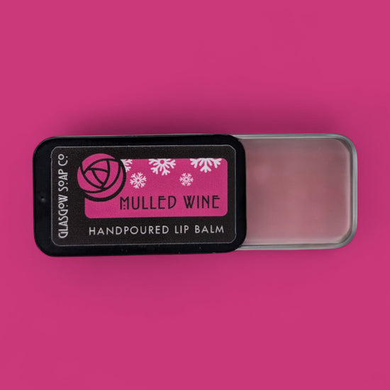 Lip balm with 'Mulled Wine' flavor on a pink background