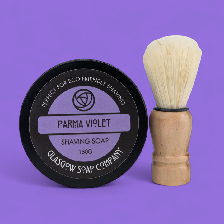 parma viiolet Shaving soap container and brush on a purple background