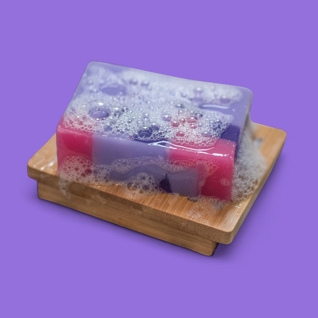 Colorful soap on a wooden soap dish with a purple background