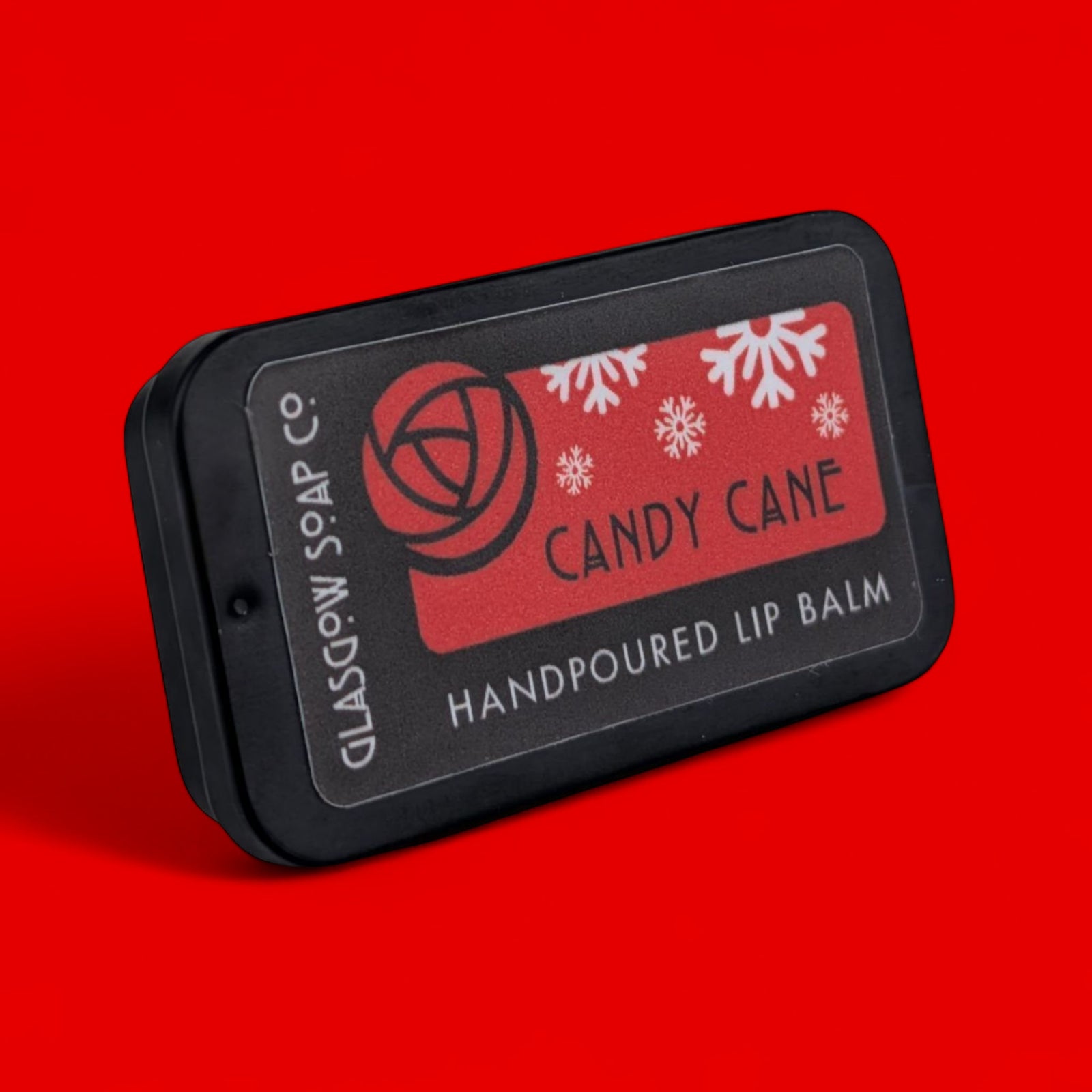 Handpoured lip balm packaging with 'Candy Cane' label on a red background