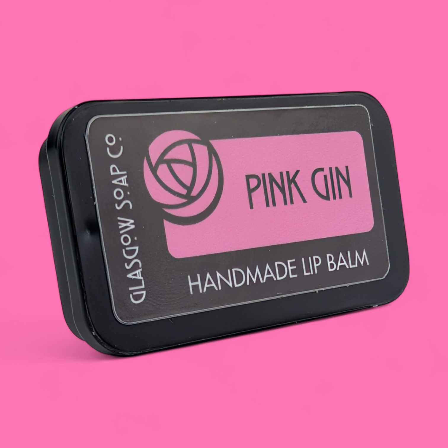 Handmade lip balm packaging with 'Pink Gin' branding on a pink background