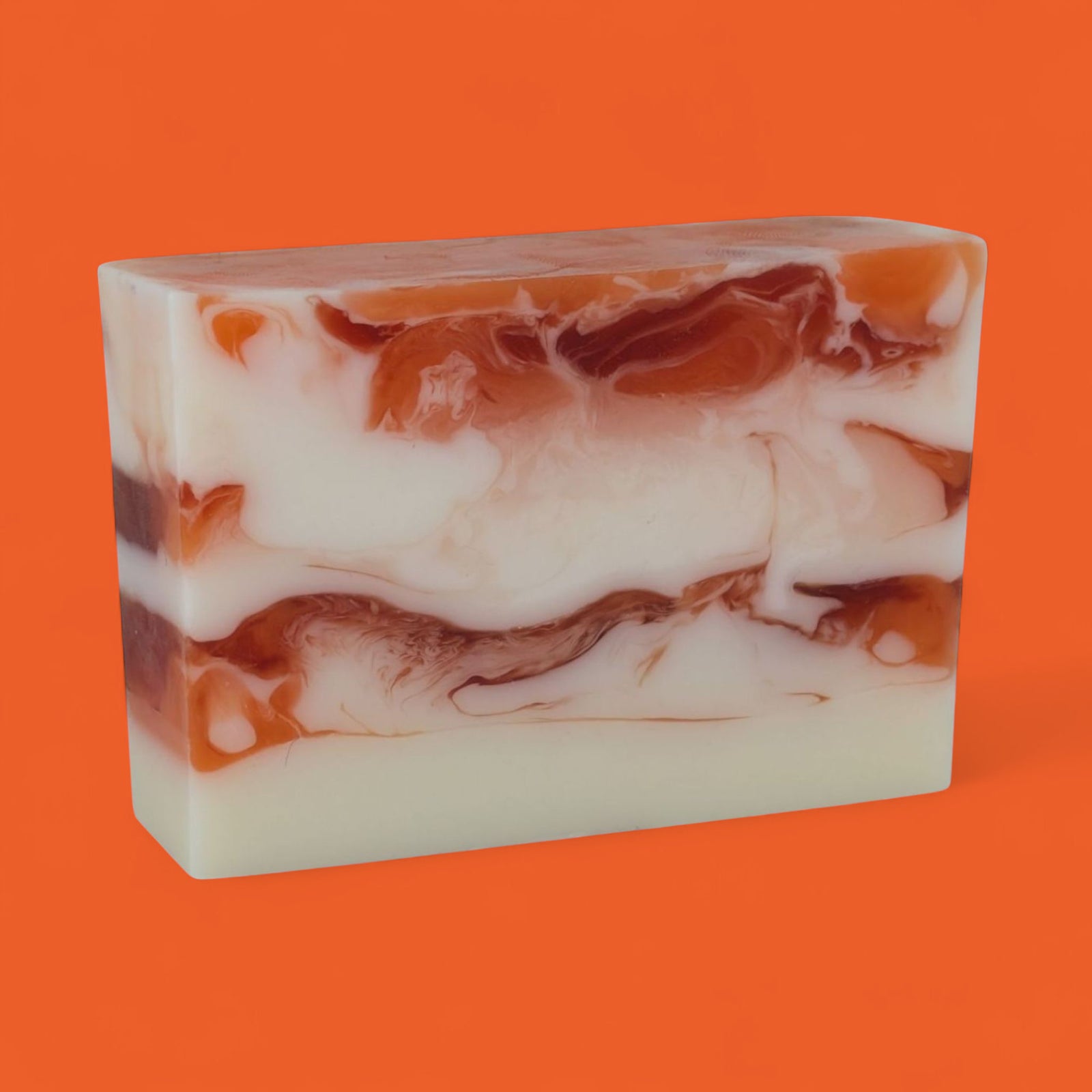 Marbled soap bar with brown and white swirls on an orange background