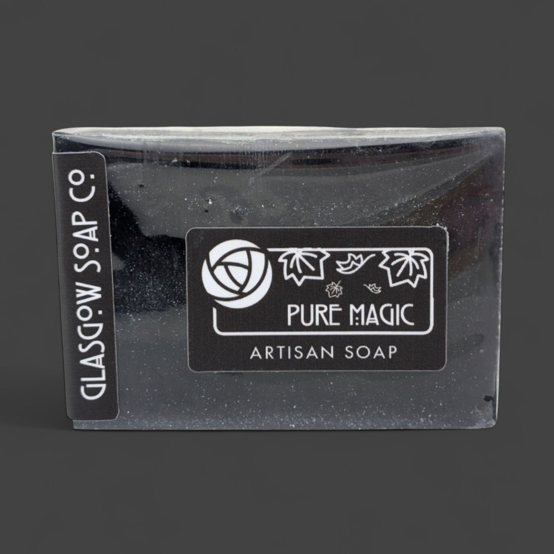 Black artisan soap bar with 'Pure Magic' label on a dark background
