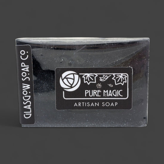 Black artisan soap bar with 'Pure Magic' label on a dark background