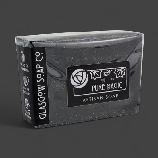 Black artisan soap bar with 'Pure Magic' label on a dark background