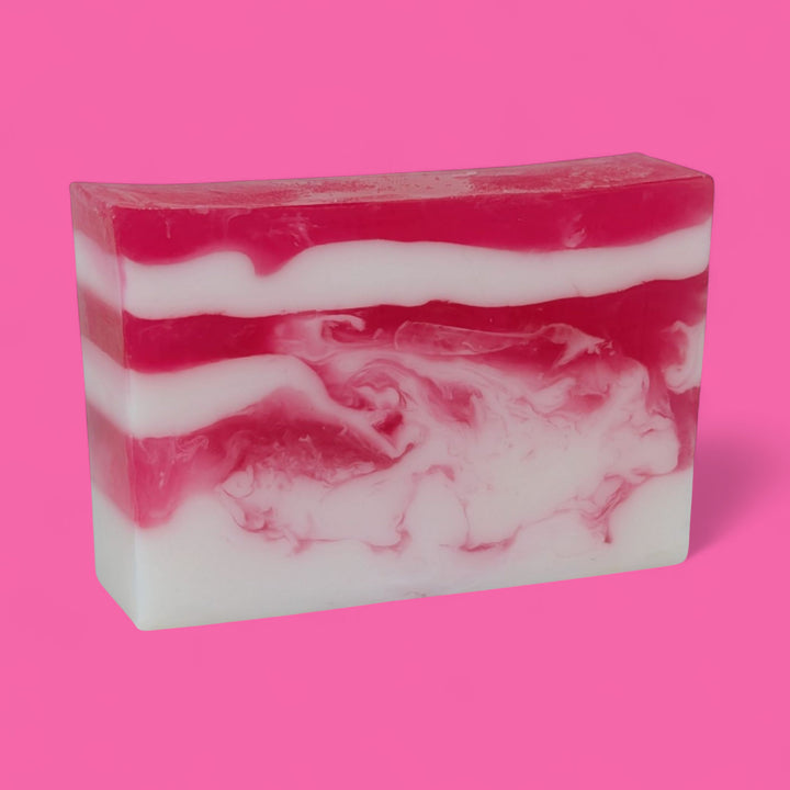 Bar of soap with pink and white swirls on a pink background