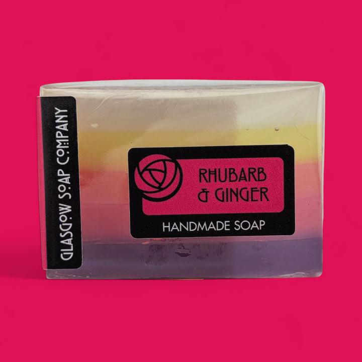Handmade soap bar with 'Rhubarb & Ginger' label on a pink background