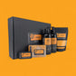 Whisky-themed gift set with bottles, boxes, and packaging on an orange background
