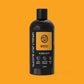 Black bottle of Glasgow Soap Company whisky bubble bath on an orange background